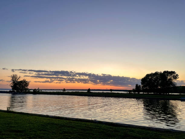 istock Sunset over a lake with trees in the foreground and clouds in the sky. 2023665732