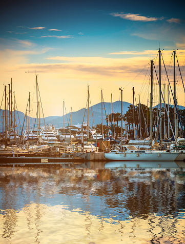 Beautiful marina view, sailboats and motorboats in port with reflection in water