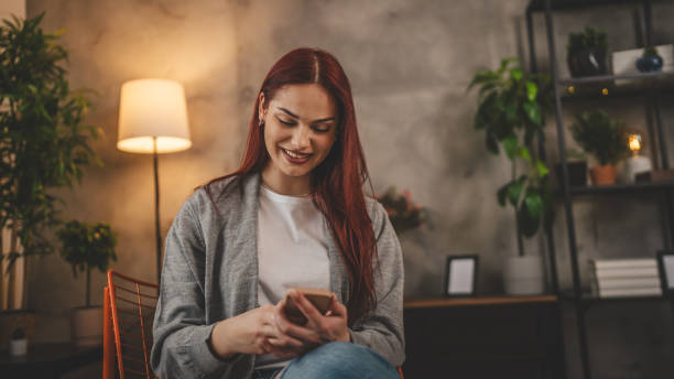 istock young woman at home use mobile phone sms texting or browse internet 2023679227