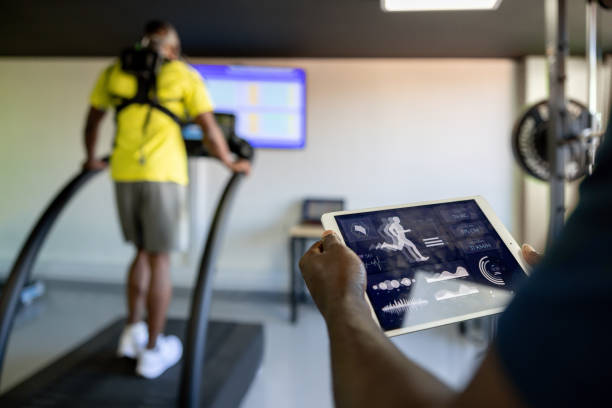 Fitness instructor using a tablet while performing a physical test at a health club