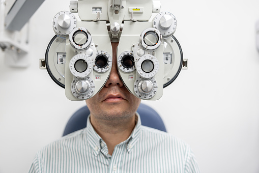 Patient getting an eye exam at the ophthalmologist - healthcare and medicine concepts