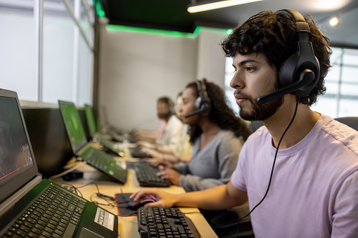 Young Latin American man studying to become a computer programmer at community college - IT education concepts