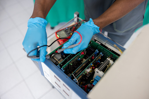 Close-up on an electrician fixing medical equipment at the hospital