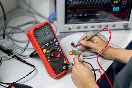 Close-up on a maintenance engineer repairing appliances using a multimeter