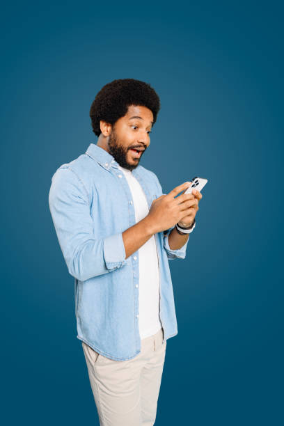 istock Astonished young man using his phone, expressing surprise and excitement 2023756575
