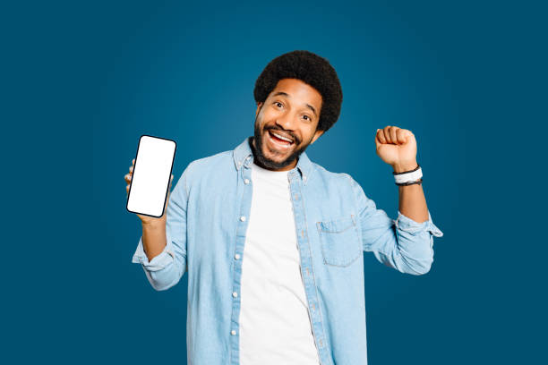 istock The exuberant young man showcases a smartphone screen while celebrating with a fist pump 2023756578