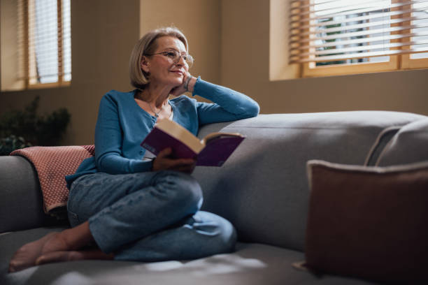 istock Elderly Woman Enjoying a Good Book in a Cozy Home Setting 2023767009