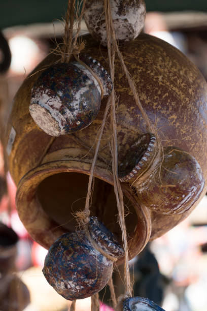 istock Sun highlights on a bundle of yellow  ceramic jugs hanging on ropes   in pottery workshop 2023777968