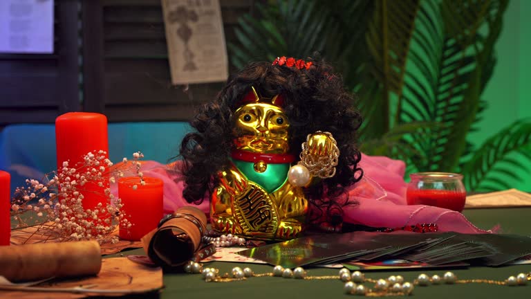 Golden cat Maneki-Neko on table with its candles in smoke esoteric spa salon