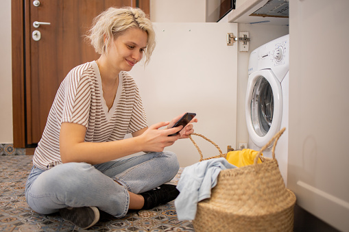 Young woman doing her laundry at home