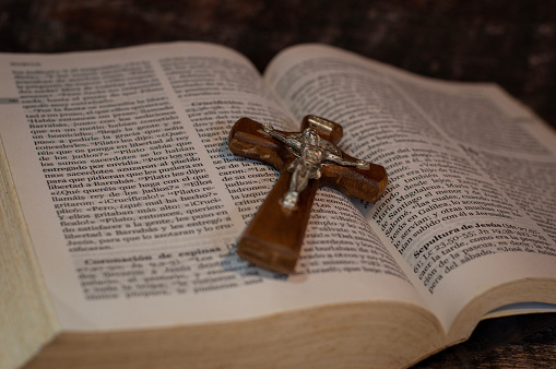 Wooden cross with a metal christ on the open bible