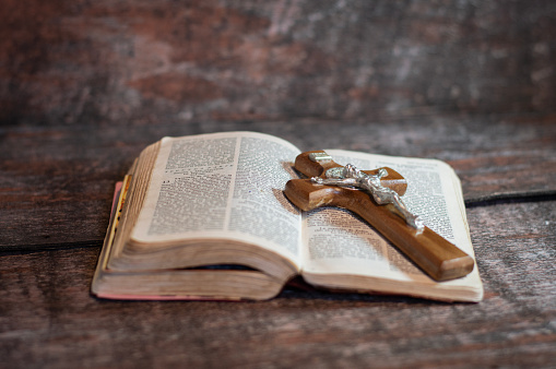 Metal crucifix on wooden cross and bible, elements for prayer