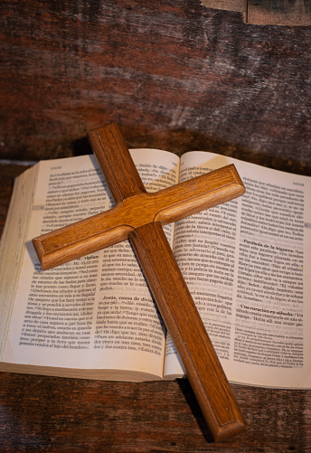 Large rustic wooden cross on a small open bible