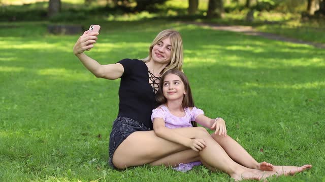 Mother and daughter taking a selfie in the park