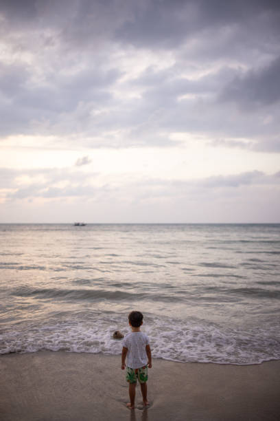 istock Little boy standing by the sea 2023859982