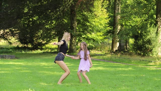 Mother and daughter jumping and holding hands in the park