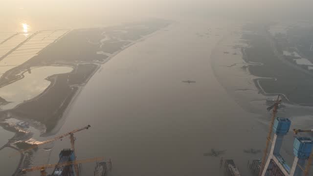 Aerial video of the under construction cross sea bridge at sunrise