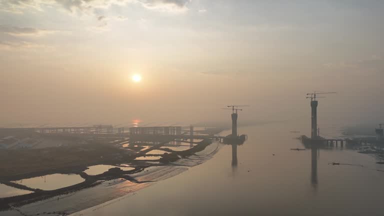 Aerial video of the under construction cross sea bridge at sunrise