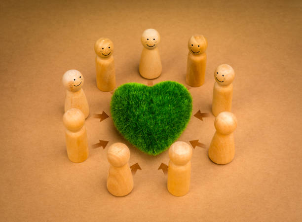 istock Teamwork, revitalizing volunteer group, cooperation community eco sustainability, environment responsibility concepts. Green heart surrounded with wooden people figures on recycle paper background. 2023926149