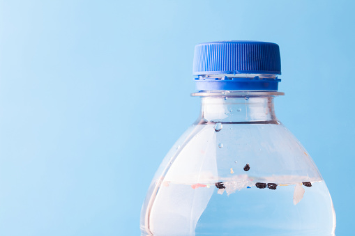 microplastic problem in bottled water, on a light blue background