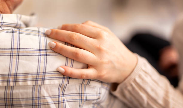 istock Comforting hand on shoulder of man 2023960052