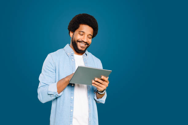 istock Engaged and content Brazilian young man, freelancer or student using a tablet 2023960191