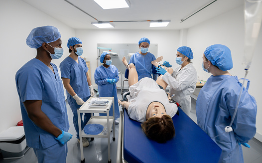 Latin American doctor teaching students how to attend a childbirth in medical school - healthcare and medicine concepts