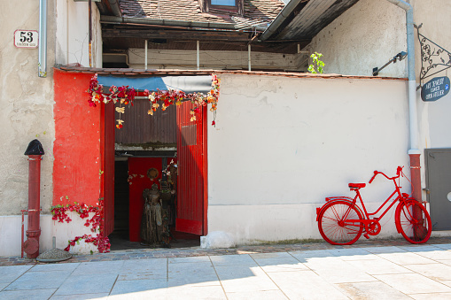 Zagreb Croatia - May 23 2011; urban backstreet with red door opening and old red bicycle leaning on wall.