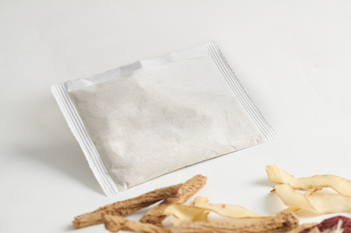 Porous bags filled with powdered Chinese herbs, isolated on a white background