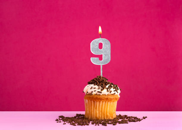 istock Birthday celebration with candle number 9 - Chocolate cupcake on pink background 2024131036