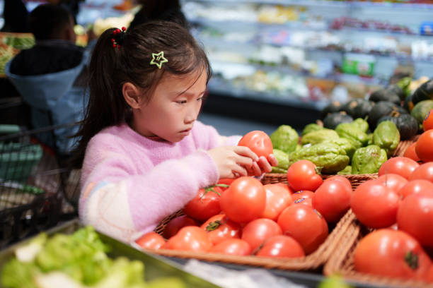 istock little girl buying tomatoes 2024242764