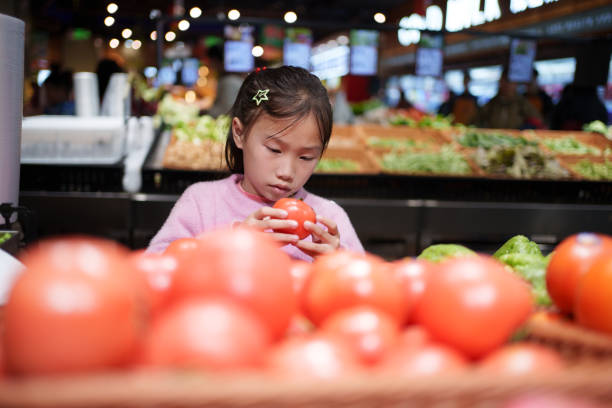 istock Little girl buying tomatoes 2024243282