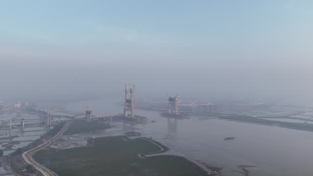 Early morning, aerial video of the under construction cross sea bridge