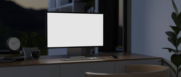 istock A modern dark home office at night with a computer mockup and decor on a minimal wooden table. 2024275038