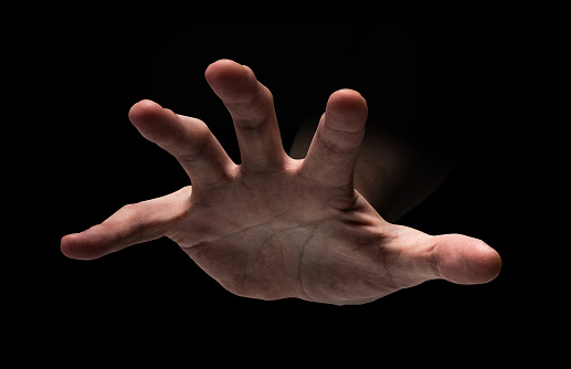 A hand approaching from the darkness, a creeping evil hand, a horror image