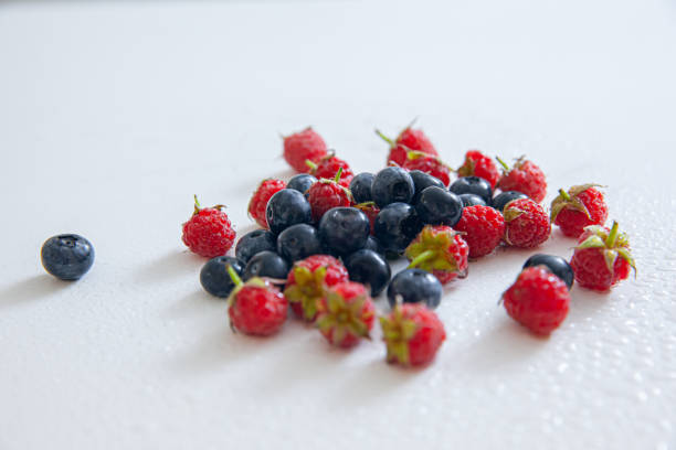 group of fresh blueberries and raspberries isolated on white background