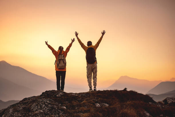 istock Two hikers are standing in winner pose at mountain top 2024330926