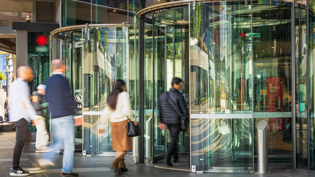 4K Footage Time lapse of Crowded Commuter business people entering and leaving office building via automatic Revolving Door in Melbourne, Australia