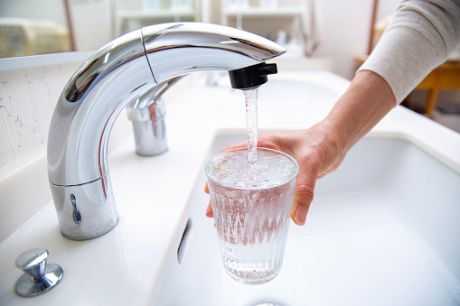 Japan's lifeline, pouring tap water into a glass,