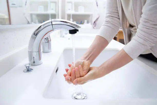 Hands of a woman washing her hands at the sink, a lifeline in Japan