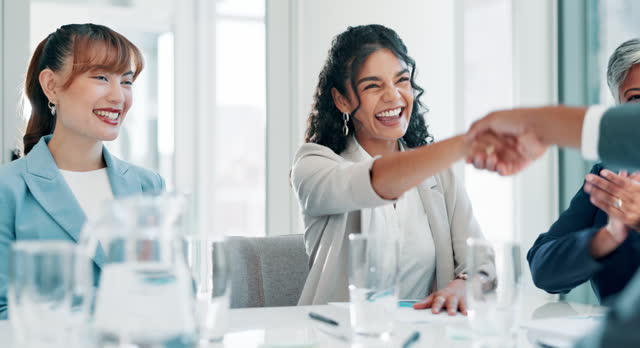 Handshake, celebration and business people in meeting, agreement or teamwork with b2b deal or thank you. Smile, group or startup with women or applause with partnership or collaboration with contract