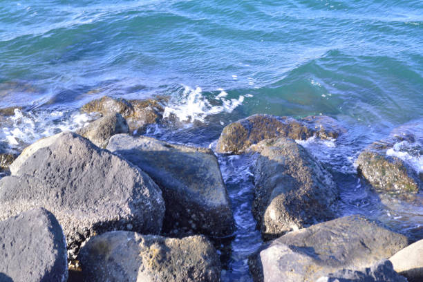 The dazzling splash of the sea on the beach hitting the rocky reef