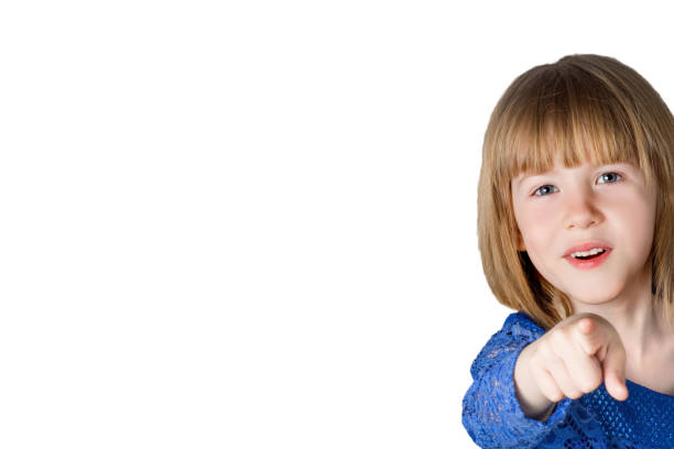 Little girl child points her finger forward. Isolated on white background.
