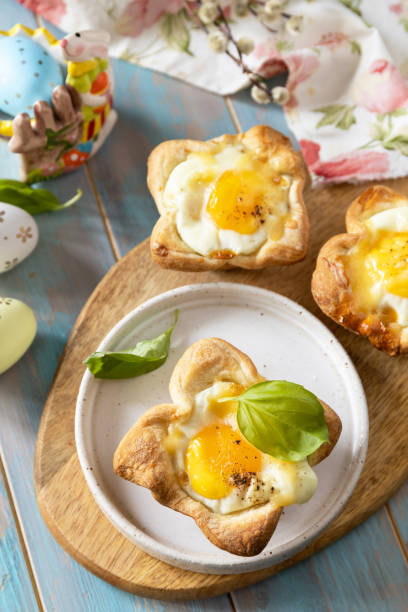 istock Scrambled eggs in puff pastry with cheese and bacon. Easter breakfast on a festive table. 2024445881