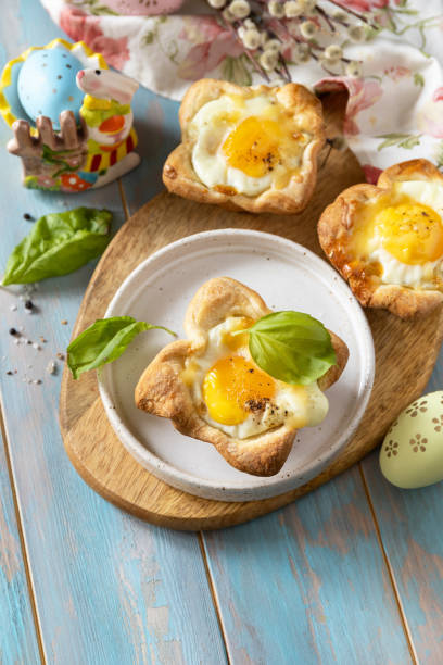 istock Scrambled eggs in puff pastry with cheese and bacon. Easter breakfast on a festive table. Copy space. 2024445886