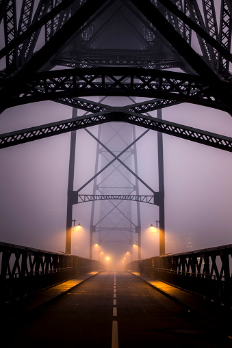 View of Dom Luis I Iron Bridge in thick fog at night, Porto, Portugal.