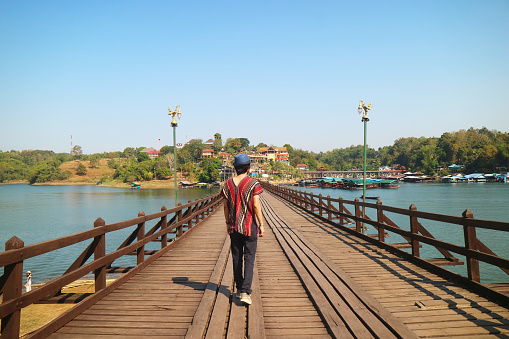 Traveler Walking on Mon Bridge Songkalia River, the Iconic Landmark of Sangkhlaburi District, Kanchanaburi, Thailand
