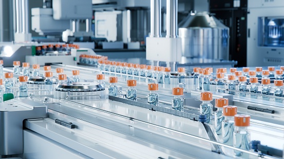 Advanced Bright Modern Pharmaceutical Factory. Medical Ampoule Production Line. Rows of Glass Vials with Orange Caps on Conveyor Belt. Vaccine Production Facility. Medication Manufacturing Process.