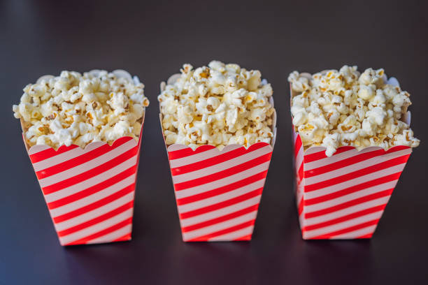 istock Popcorn in red and white container on a dark background 2024527730