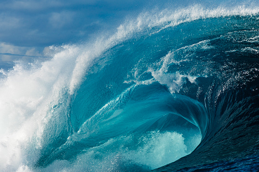 Close up to powerful blue wave breaking in the open ocean over a shallow reef bombora. Photographed off the south west coast of Australia.